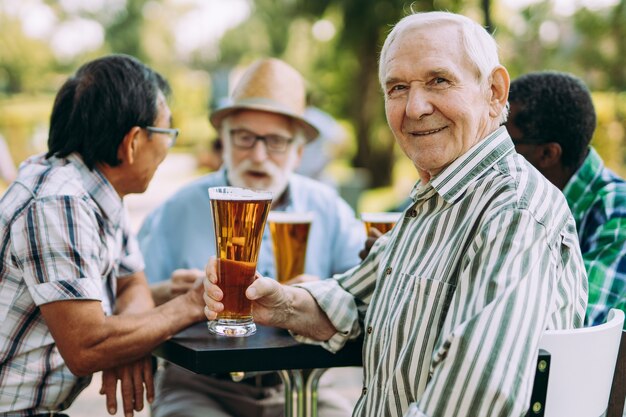 Gruppe älterer Freunde, die im Park ein Bier trinken. Lifestyle-Konzepte zu Seniorität und drittem Alter