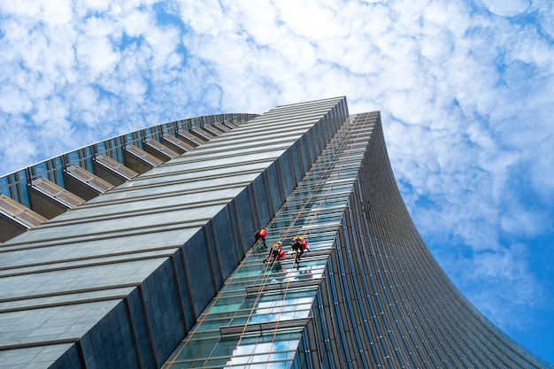 Gruppe Alpinisten im Dienst für die Fensterreinigung von Wolkenkratzergebäuden