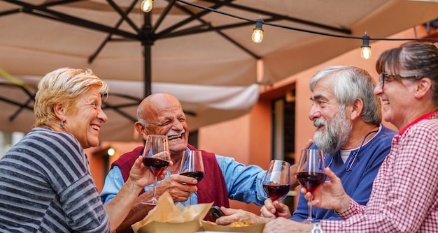 Foto gruppe alter menschen, die im freien essen und trinken ältere paare, die gemeinsam spaß haben