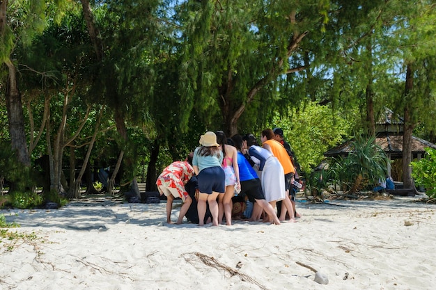 Gruppe Asiaten, die zusammen ein Foto am Strand machen