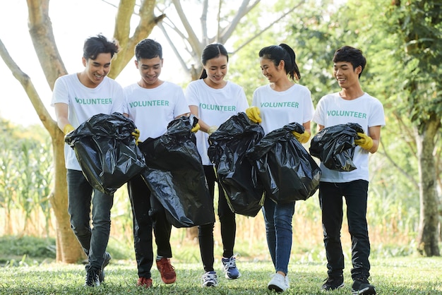 Gruppe asiatischer junger Leute, die es genießen, Zeit zusammen zu verbringen und Müll im Park zu sammeln?
