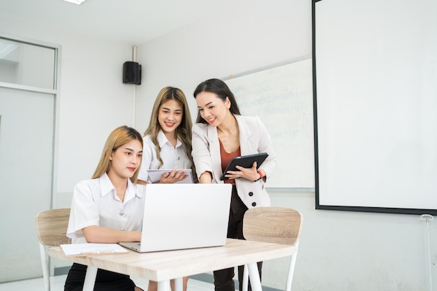 Gruppe asiatischer studentinnen der universität erklären und präsentieren mit lehrerin professorin im klassenzimmer