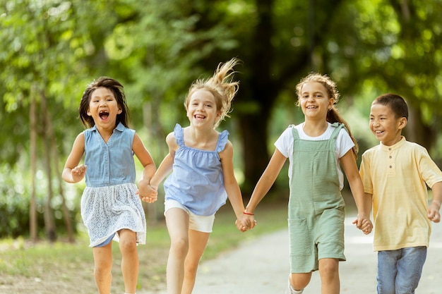 Gruppe asiatischer und kaukasischer Kinder, die sich im Park amüsieren