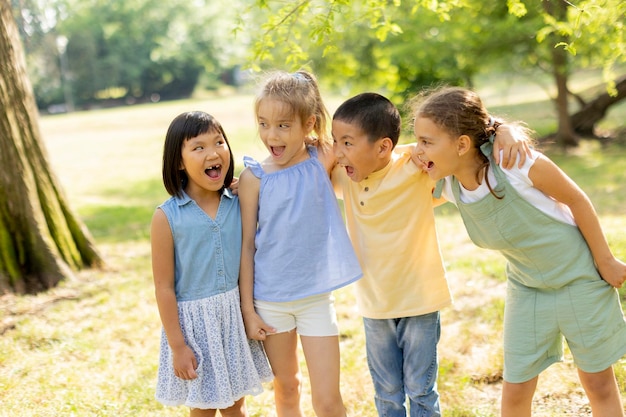 Gruppe asiatischer und kaukasischer Kinder, die sich im Park amüsieren