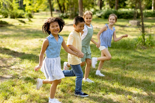 Gruppe asiatischer und kaukasischer Kinder, die sich im Park amüsieren