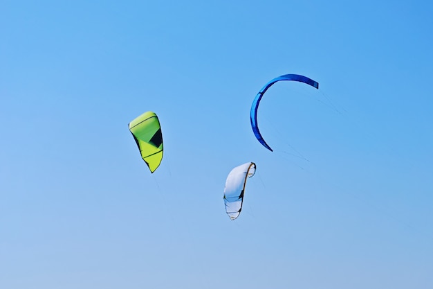 Gruppe bunte Drachen von Kiteboarding fliegt in den blauen Himmel