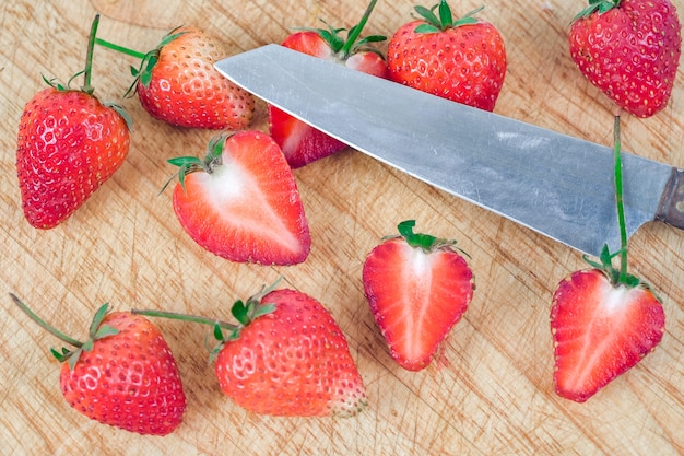 Gruppe Erdbeeren auf hölzernem Hintergrund.