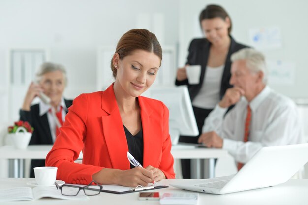 Gruppe erfolgreicher Geschäftsleute, die im modernen Büro arbeiten Geschäftsfrau im Vordergrund