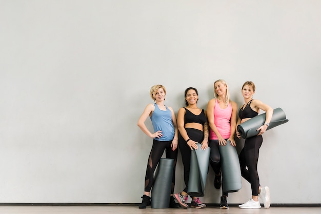 Foto gruppe erwachsene frauen, die an der turnhalle aufwerfen