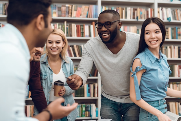 Gruppe ethnische multikulturelle sprechende und lachende Studenten.