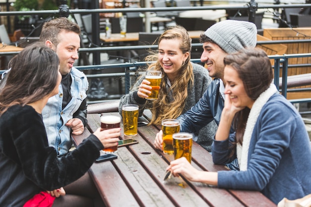 Gruppe Freunde, die ein Bier an der Kneipe in London genießen