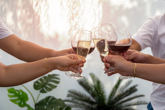 Gruppe Freunde, die einen Toast mit den Gläsern Rotwein im Freien im Sommer anheben.