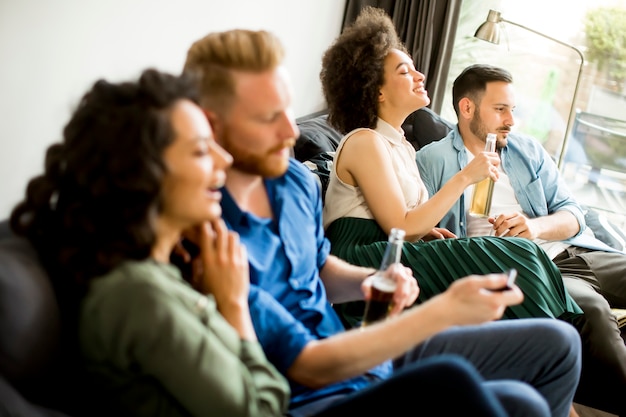 Gruppe Freunde, die fernsehen, Apfelwein trinken und Spaß haben