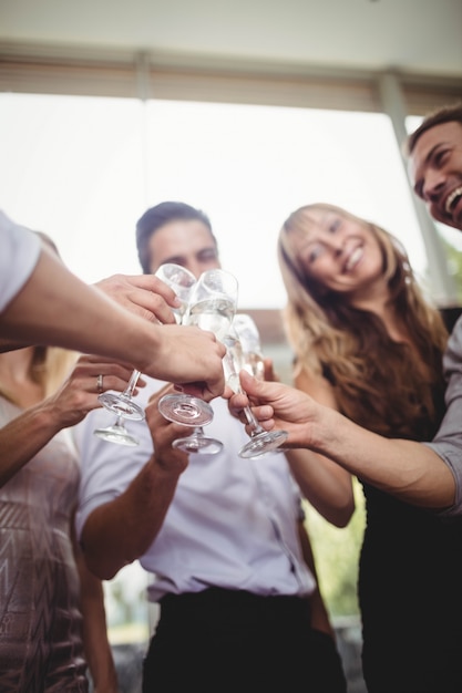 Gruppe Freunde, die Gläser Champagner an der Party lächeln und rösten