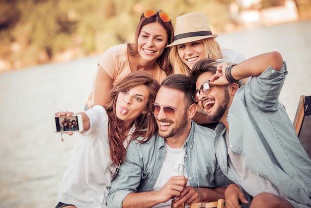 Gruppe Freunde, die selfie auf dem Strand nehmen