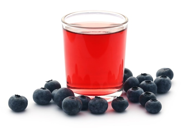 Gruppe frische Blaubeeren mit Saft in einem Glas auf weißem Hintergrund