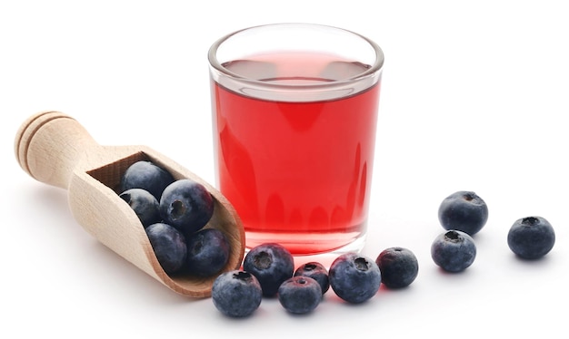 Gruppe frische Blaubeeren mit Saft in einem Glas auf weißem Hintergrund