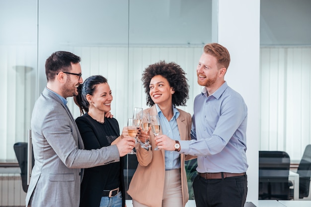 Gruppe Geschäftsleute, die ihre Flöten des Champagners als Erfolg klirren.