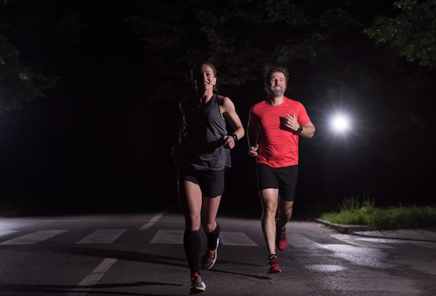 Gruppe gesunde Leute, die im Stadtpark, Läufer rütteln, team am Nachttraining