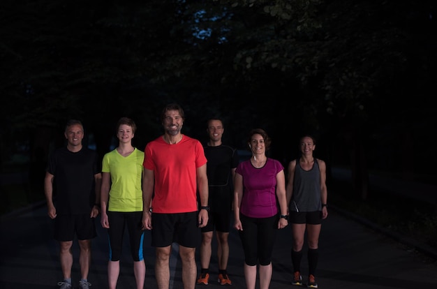 Gruppe gesunde Leute, die im Stadtpark, Läufer rütteln, team am Nachttraining