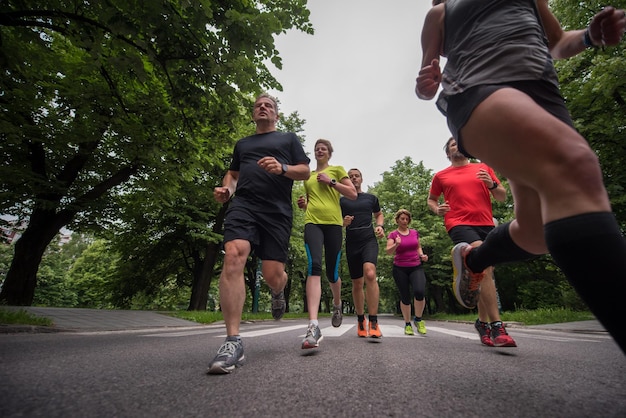 Gruppe gesunde Leute, die im Stadtpark rütteln, Läufer team auf Morgentraining