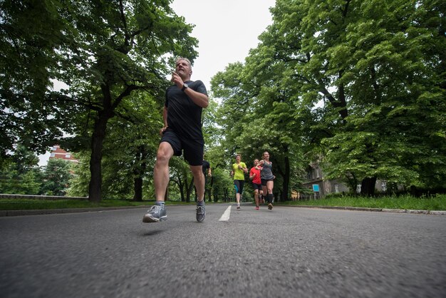 Gruppe gesunde Leute, die im Stadtpark rütteln, Läufer team auf Morgentraining