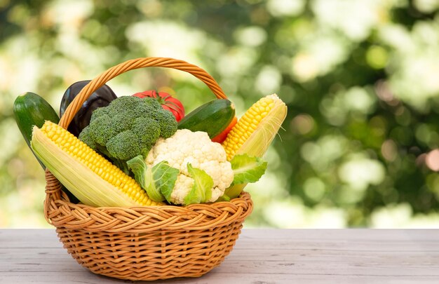 Gruppe Gesundes, frisches Gemüse in einem Holzkorb, mit Vitamin C aus Salat, Tomate, Karotte, Blumenkohl und Ingwer, ist gut für den Körper und die Ernährung auf dem Tisch im Naturhintergrund.