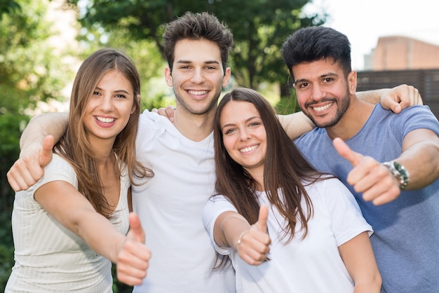 Gruppe glückliche Freunddaumen oben