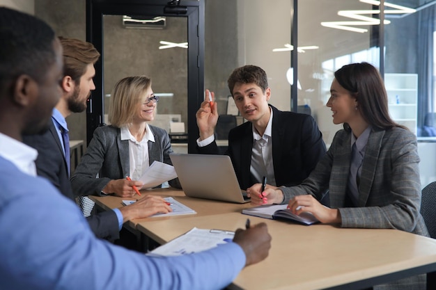 Gruppe glückliche junge Geschäftsleute in einer Sitzung im Büro