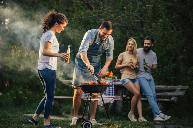 Gruppe glücklicher Freunde, die draußen grillen