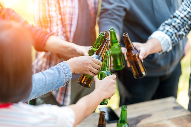 Gruppe glücklicher Freunde, die gesunden Lebensstil leben und sich entspannen, mit Bier jubeln und Bier trinken