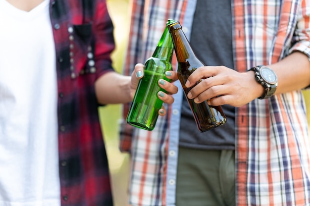 Gruppe glücklicher Freunde, die gesunden Lebensstil leben und sich entspannen, mit Bier jubeln und Bier trinken