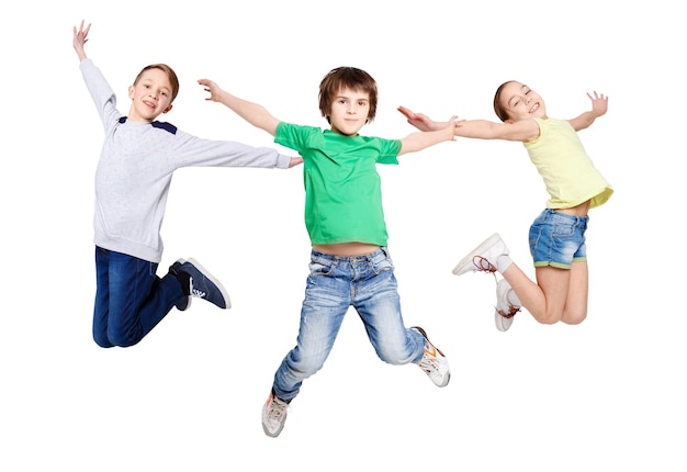 Gruppe glücklicher, fröhlicher Kinder, die auf isolierten weißen Studiohintergrund springen. Kindheit und Freiheit, aktives Lifestyle-Konzept, Kopierraum