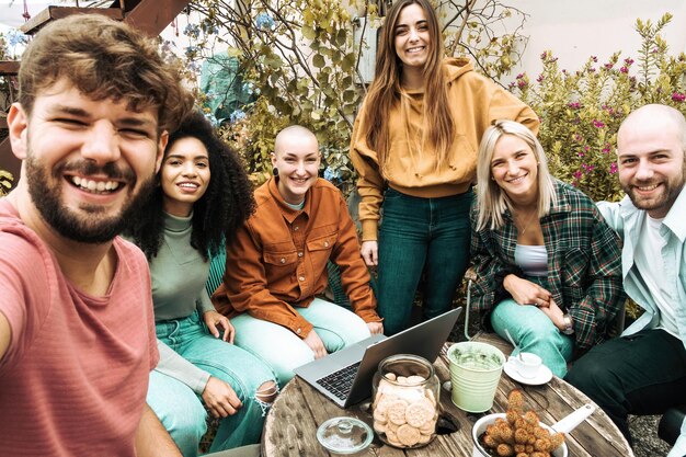 Gruppe glücklicher junger Coworking-Studenten, die ein Erinnerungs-Selfie auf dem Dach machen, lächeln und gemeinsam Spaß haben