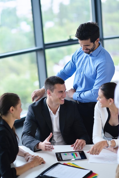 Gruppe glücklicher junger Geschäftsleute bei einer Besprechung im Büro