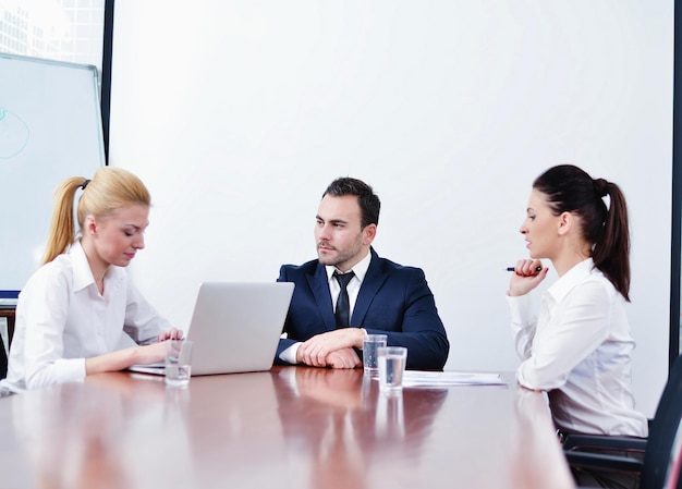 Gruppe glücklicher junger Geschäftsleute bei einer Besprechung im Büro