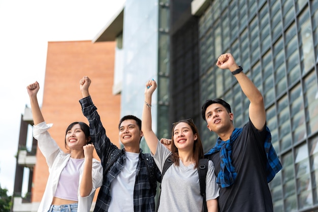 Gruppe glücklicher junger Unternehmer mit erhobenen Händen und lachend, um den Erfolg zu feiern und aufgeregt für die erzielten Leistungen Studenten feiern den Erfolg nach dem Ende des Projekts Teamarbeitskonzept