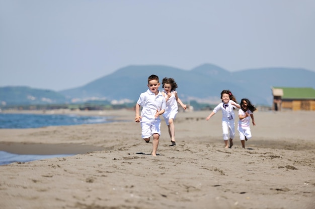 gruppe glücklicher kinder am strand, die spaß haben und spiele spielen