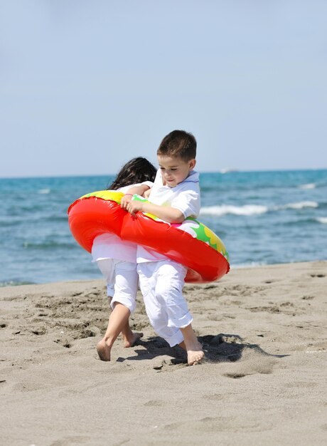 gruppe glücklicher kinder am strand, die spaß haben und spiele spielen