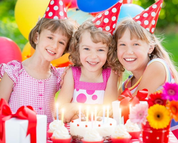 Gruppe glücklicher Kinder, die Geburtstag feiern Kinder, die Spaß im Frühlingsgarten haben