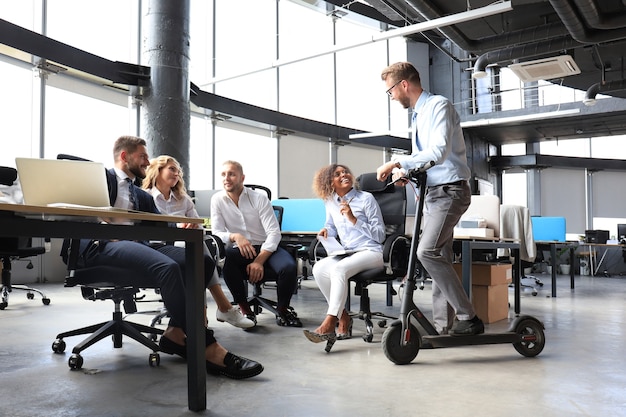 Gruppe glücklicher progressiver Geschäftsleute, die gemeinsam im Kreativbüro am Start arbeiten.