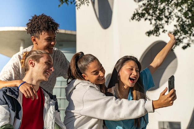 Gruppe glücklicher Teenager-Freunde, die ein Selfie mit dem Telefon machen und auf der Stadtstraße lachen