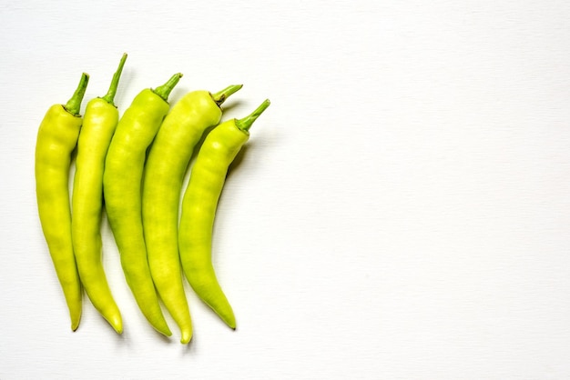 Gruppe grüner Paprika auf weißem Holzhintergrund hat Kopierraum