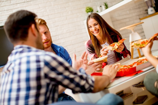 Gruppe junge Freunde, die Pizza essen