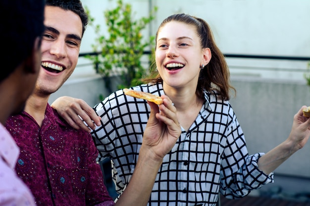 Gruppe junge freunde mit pizza und flaschen des getränks