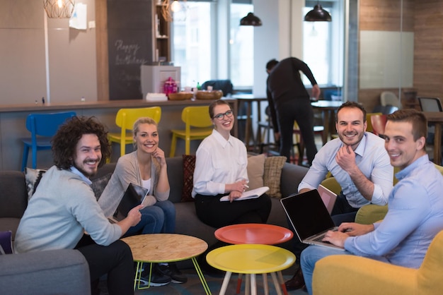 Gruppe junge Geschäftsleute, die Unternehmensplan am modernen Startbürohaus besprechen