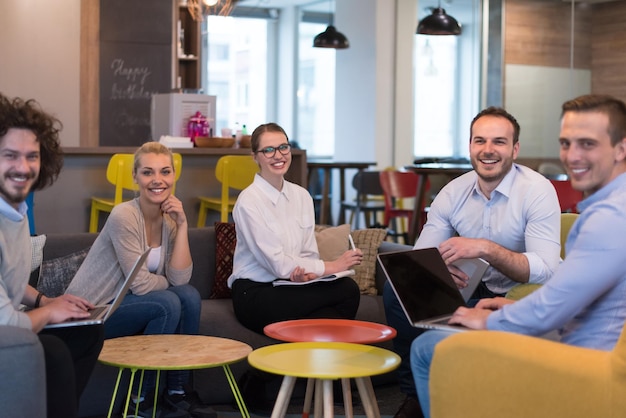 Gruppe junge Geschäftsleute, die Unternehmensplan am modernen Startbürohaus besprechen