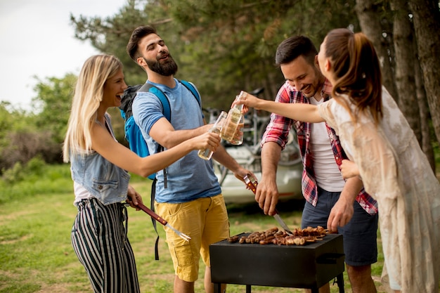 Gruppe junge Leute, die Grillparty in der Natur genießen