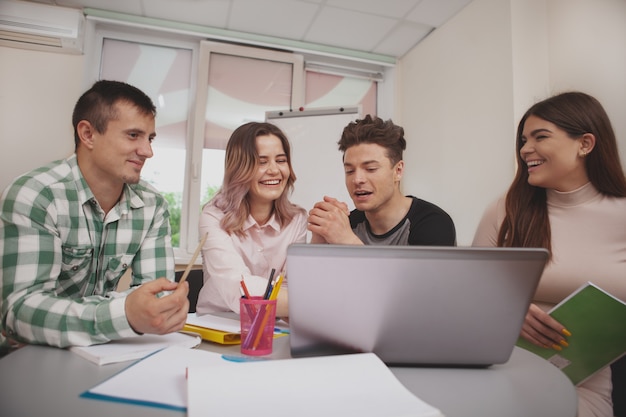 Gruppe junge Leute, die zusammen am Collegeklassenzimmer studieren