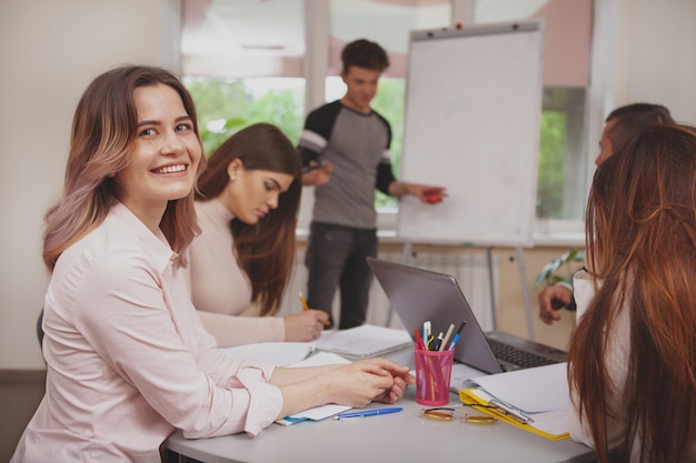 Gruppe junge Leute, die zusammen am Collegeklassenzimmer studieren